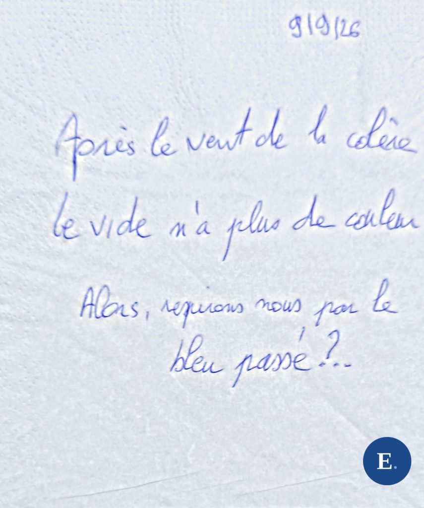 Serviette en papier blanche, gaufree, posee a plat ; trois lignes manuscrites a l encre bleue ; la date 9 9 26 ecrite dans le coin en haut ; medaillon E. bleu en bas a droite.