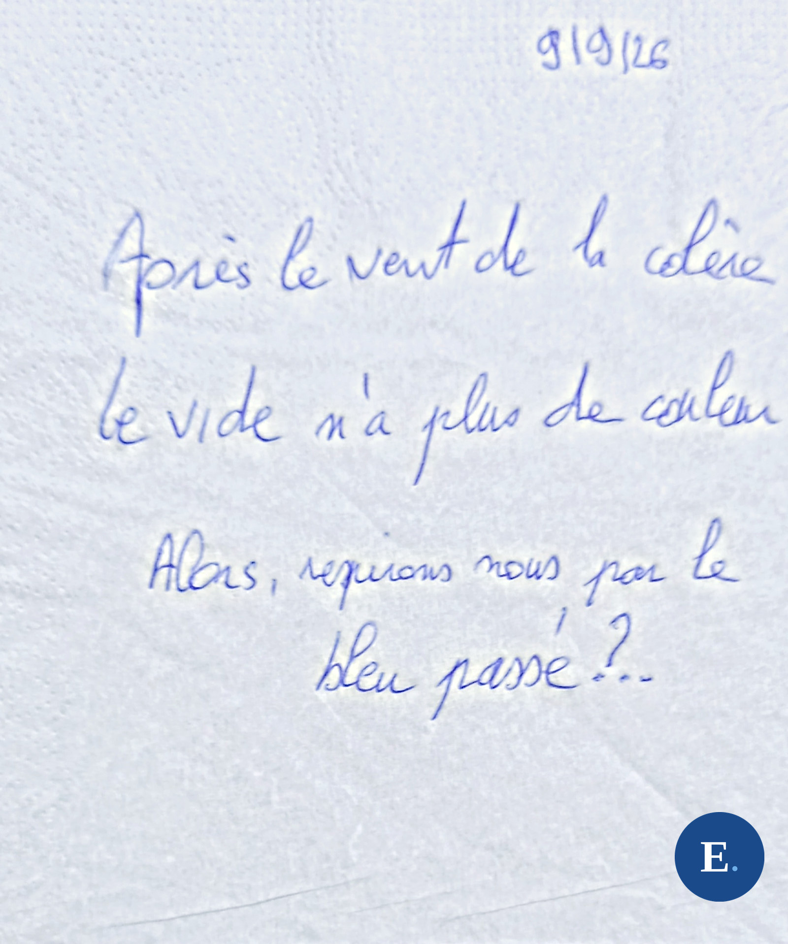 Serviette en papier blanche, gaufree, posee a plat ; trois lignes manuscrites a l’encre bleue ; la date 9 9 26 ecrite dans le coin en haut ; medaillon E. bleu en bas a droite.